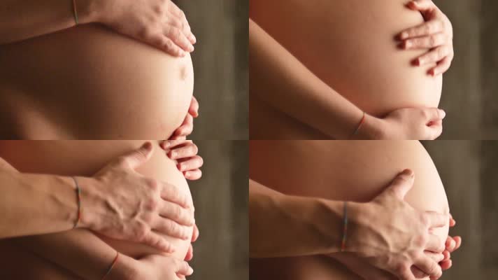 怀孕孕妇夫妇爱抚肚子里的婴儿