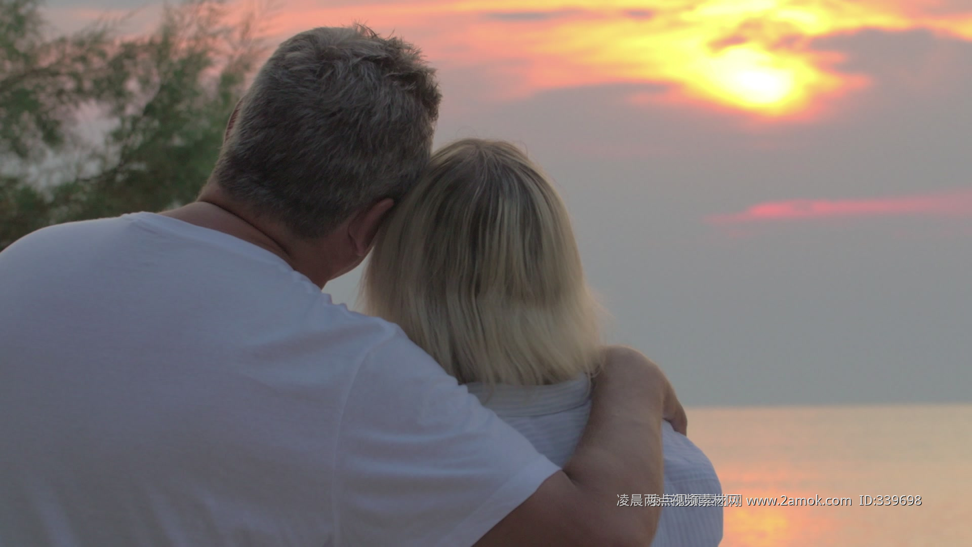 夕阳西下，幸福的老夫妻在海边的码头上拥抱，互相看着对方。照片摄影图片_ID:408905078-Veer图库