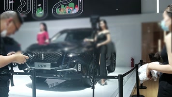 车展上的美女车模和为香车美女拍照的摄影师