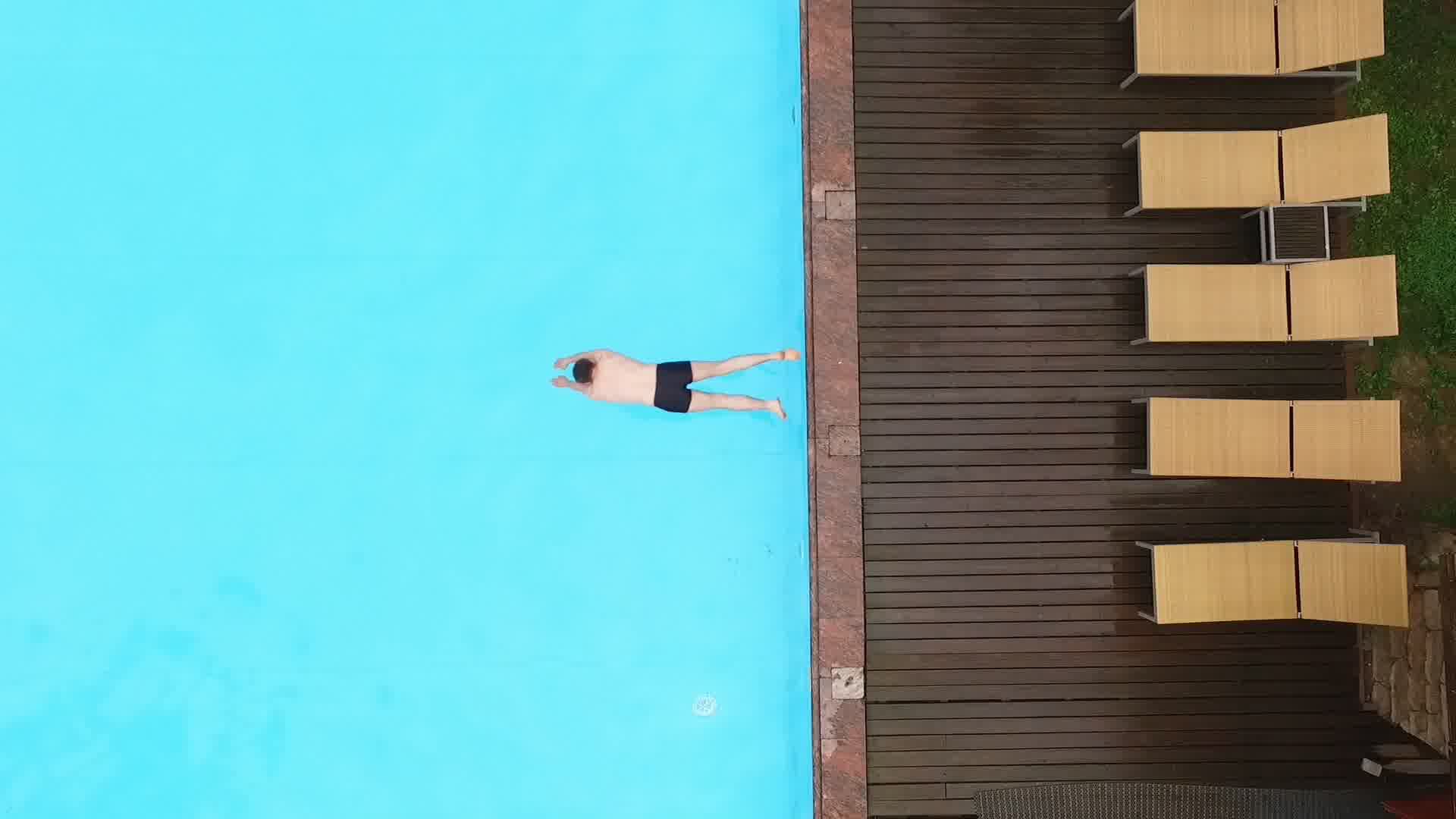 男人跳水游泳，度假酒店泳池