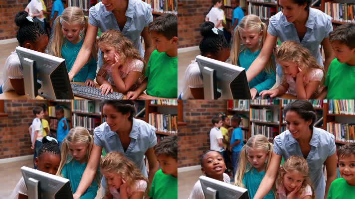 学生们看着图书馆里的电脑和老师