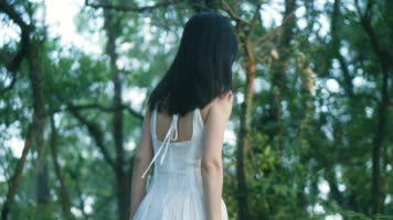 穿白色长裙的女孩在森林行走的背影4k视频