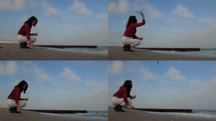 女孩坐在海滩上向大海扔卵石