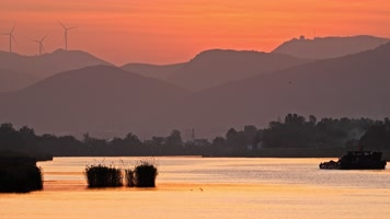 傍晚黄昏货轮船航行在河道农村远山