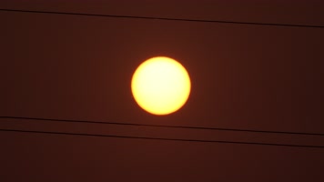 夏天麦田里电线杆中间的太阳