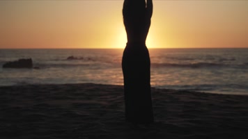 美女迎着太阳在海边起舞