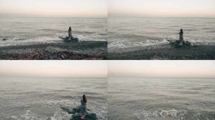 女孩站在石头上面朝大海