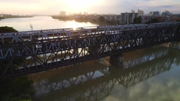 4K航拍夕阳下高铁和谐号驶过江上大桥