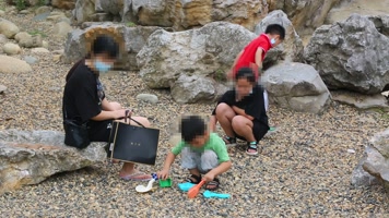 公园假山旁玩耍的小孩