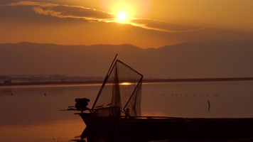 4K日出日落金色湖面渔船渔网