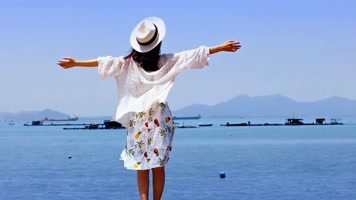 美女拥抱大海站在海边望着无边无际的大海