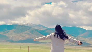 4k雪山草原美女蹦跑旅游休闲高清视频